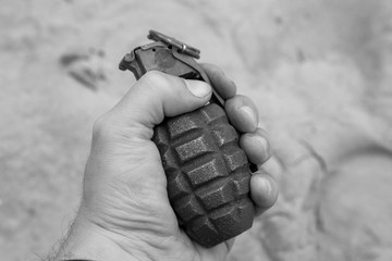 black and white photo of a military grenade in hand