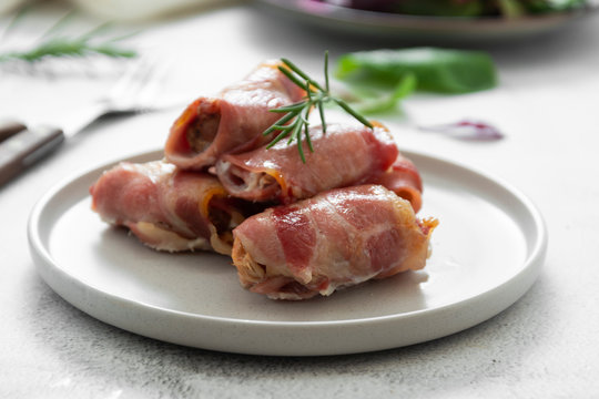 Delicious pigs in blankets, meat wrapped in bacon, homemade cooked meat bites. Bright food photo.