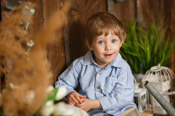 Laughing baby boy playing with Easter bunny in a green grass