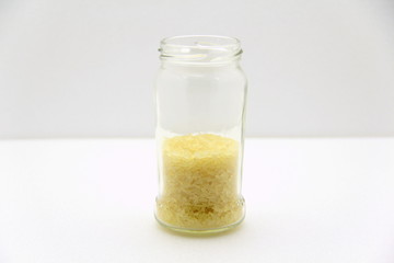 Glass jar with rice on a white background, side view.