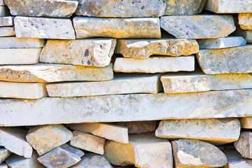 Stone wall built with blocks and marble slabs simply placed over