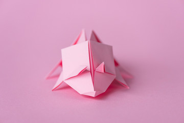selective focus of small origami rhinoceros on pink with copy space