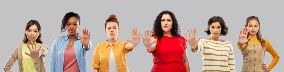 feminism, female rights and protest concept - group of different women making stopping gesture over grey background