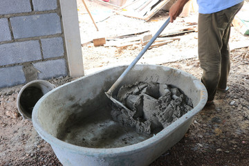 Man mixing cement for house construction.