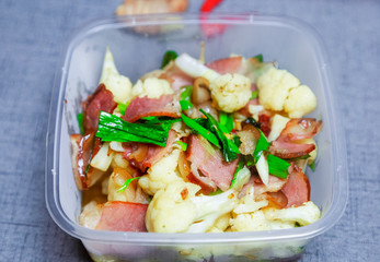 Chinese food.  Transparent takeaway lunch box.  Made from cauliflower and Chinese cured meat.  Is a common dish in China, especially in the southwest