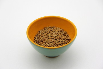 Ceramic bowl with lentils on a white background, top view
