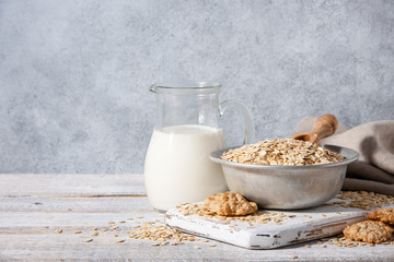 Oat flakes, milk and cookies on wooden table