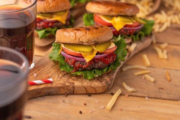 Juicy homemade french fries and soda burgers. Wooden texture with space for design. Delicious and fast food.