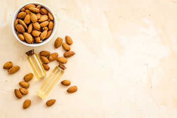 Skin care cosmetics. Almond oil in small bottles on biege background top-down copy space