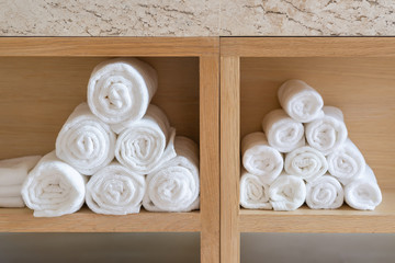 Towels white soft cotton neatly folded clothes on wooden cabinet wall built in the bathroom clean textile, concept interior for spa and hygiene