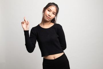 Beautiful young Asian woman cross finger.