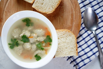 Soup with meatballs on a white plate. Selective focus