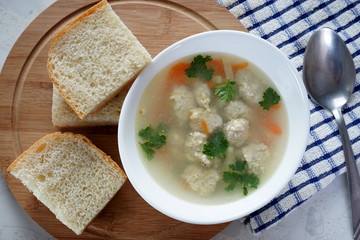 Soup with meatballs on a white plate. Selective focus