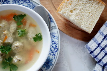 Soup with meatballs on a white plate. Selective focus