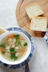 Soup with meatballs on a white plate. Selective focus