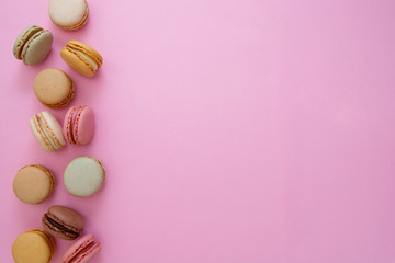 Colorful abstract pink background with french macaroons cookies, copy space. Feminine or beauty background.