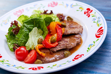 beef with salad on the wooden background