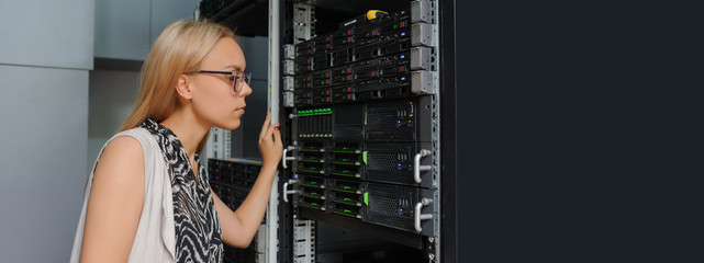 Young woman engineer It technician in the data center server room.