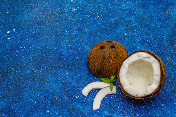 Ripe coconut cut on two half isolated on bright blue marine background