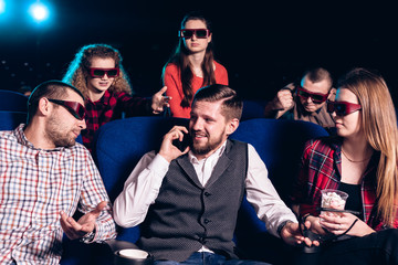 The guy speaks on the phone and interferes with watching a movie in a movie theater. Stock photo of...