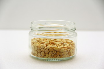 Glass jar with groats on a white background, side view.