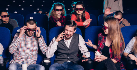 The guy speaks on the phone and interferes with watching a movie in a movie theater. Stock photo of...