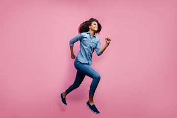 Full body profile side photo of active afro american youth girl jump run fast after spring black...
