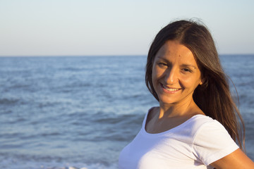 Fototapeta na wymiar Woman dressed in white barefoot on the beach sand