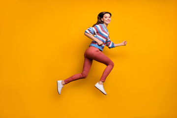 Full length profile side photo of cheerful girl jump run fast after spring discounts wear sweater sneakers isolated over shine color background