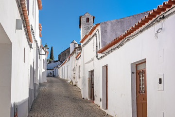 Fototapeta na wymiar White houses on a narrow street in an ancient Portuguese town