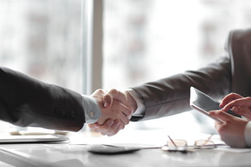 close up. the financial partners shaking hands over a Desk