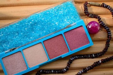 Box with powder and sea salt, beads. Wood background. Colors of Thatch, Silk, Rose Taupe, Mauve Taupe, Maya Blue. Concept of female cosmetics, care, relaxation in the summer.
