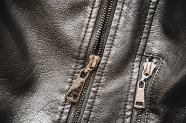 Metal zipper on a black women's jacket. Women's leather jacket top view. Black texture of genuine...