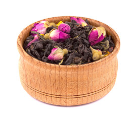 Dried black tea with slices of dried cherry, safflower petals in a wooden bowl, delicious, natural