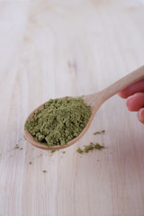 Japanese matcha, green tea in wooden spoon on white background.