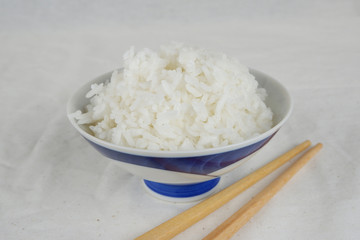 White rice on ceramic plate top view with bamboo chopstick