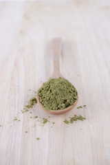 Japanese matcha, green tea in wooden spoon on white background.