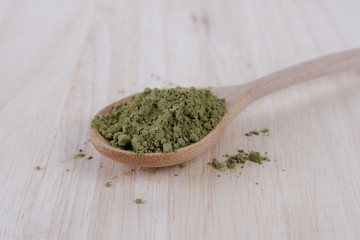 Japanese matcha, green tea in wooden spoon on white background.