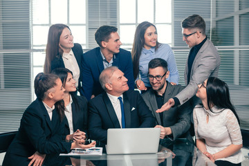 boss and happy business team looking at laptop screen.