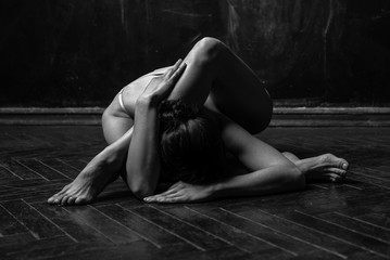 Young Flexible gymnast woman stretching and posing in studio. Black and white photography