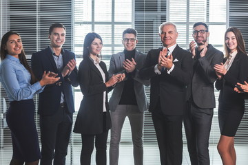 Fototapeta premium group of happy employees applauding their success