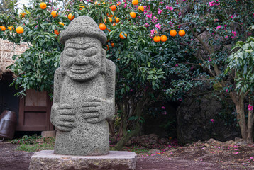 A landscape with mandarin orange and Dol Harubang made of basalt, a symbol of Jeju Island.