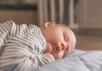 Baby boy lying on front in living room 