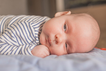 Baby boy lying on front in living room 