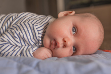 Baby boy lying on front in living room 