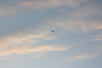 Sunset over the forest, red, yellow, purple clouds. plane in the sunset sky