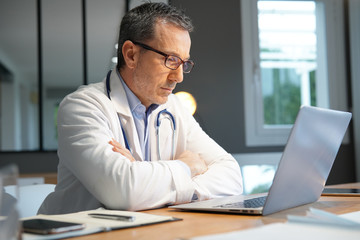 Obraz premium Doctor in office working on laptop