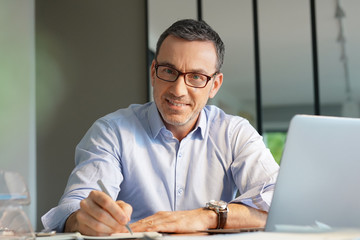 Business manager working in office on laptop