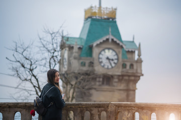 Girl in a black shirt with a clock tower
