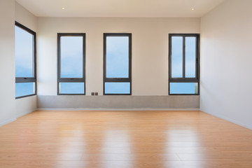 Empty room interior with windows overlooking the blue sky, Beautiful wooden floor and white wall modern architecture